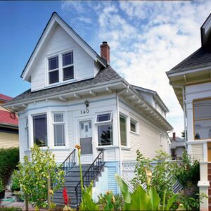 Gallery1 A charming little white house with blue accents and white paint with varied windows.
