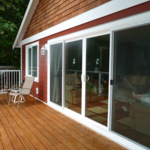 Gallery24 A red house with cedar shakes and a large glass door with white siding and trim.
