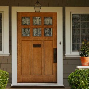 Masthead_EntryDoorsreduced A wooden entry door on an exterior of a grey house with white trim.