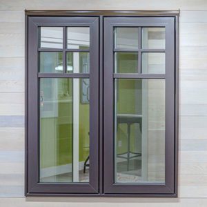 Windows with brown trim and grey siding on a house.