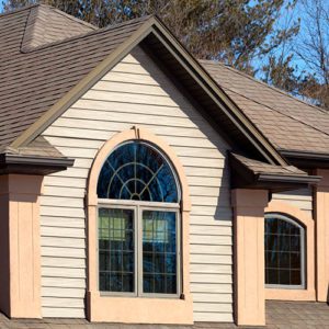 A beige and brown house with a curved window.