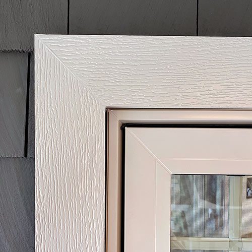 Door siding on a grey house with white trim.