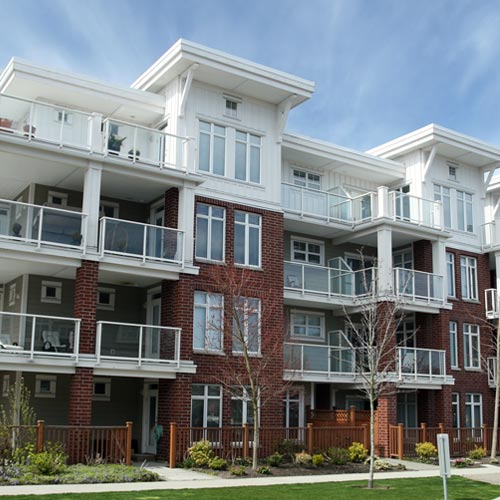 A multi-floored apartment building with many units and windows.